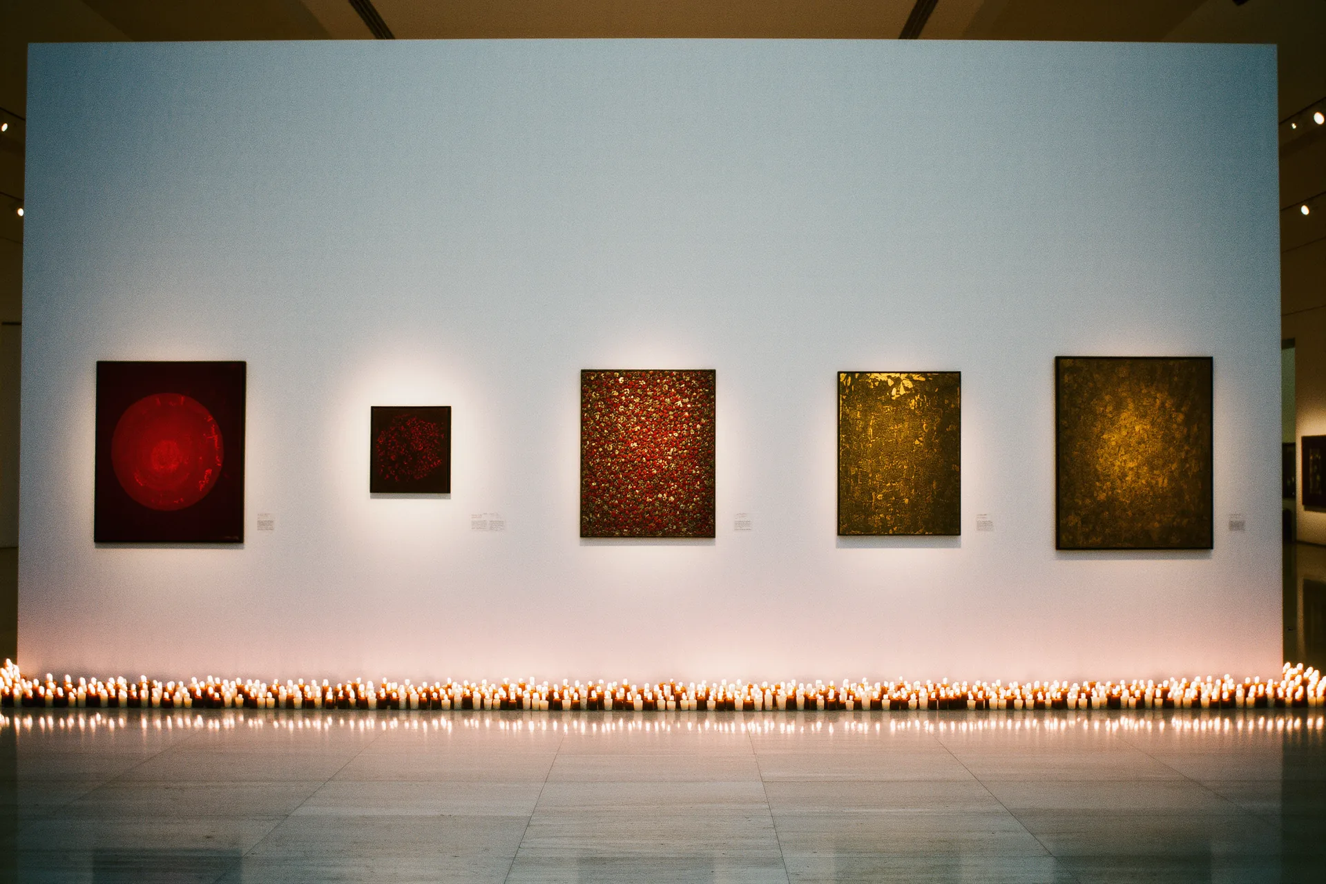 Mur de galerie épuré présentant quelques œuvres soigneusement espacées et éclairées