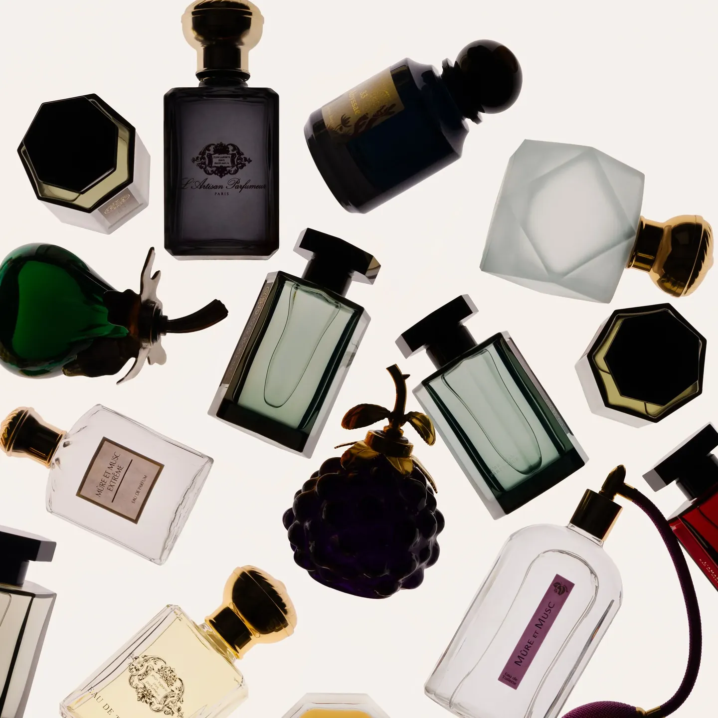 Flacons de L'Artisan Parfumeur disposés à plat, dont le flacon en forme de mûre