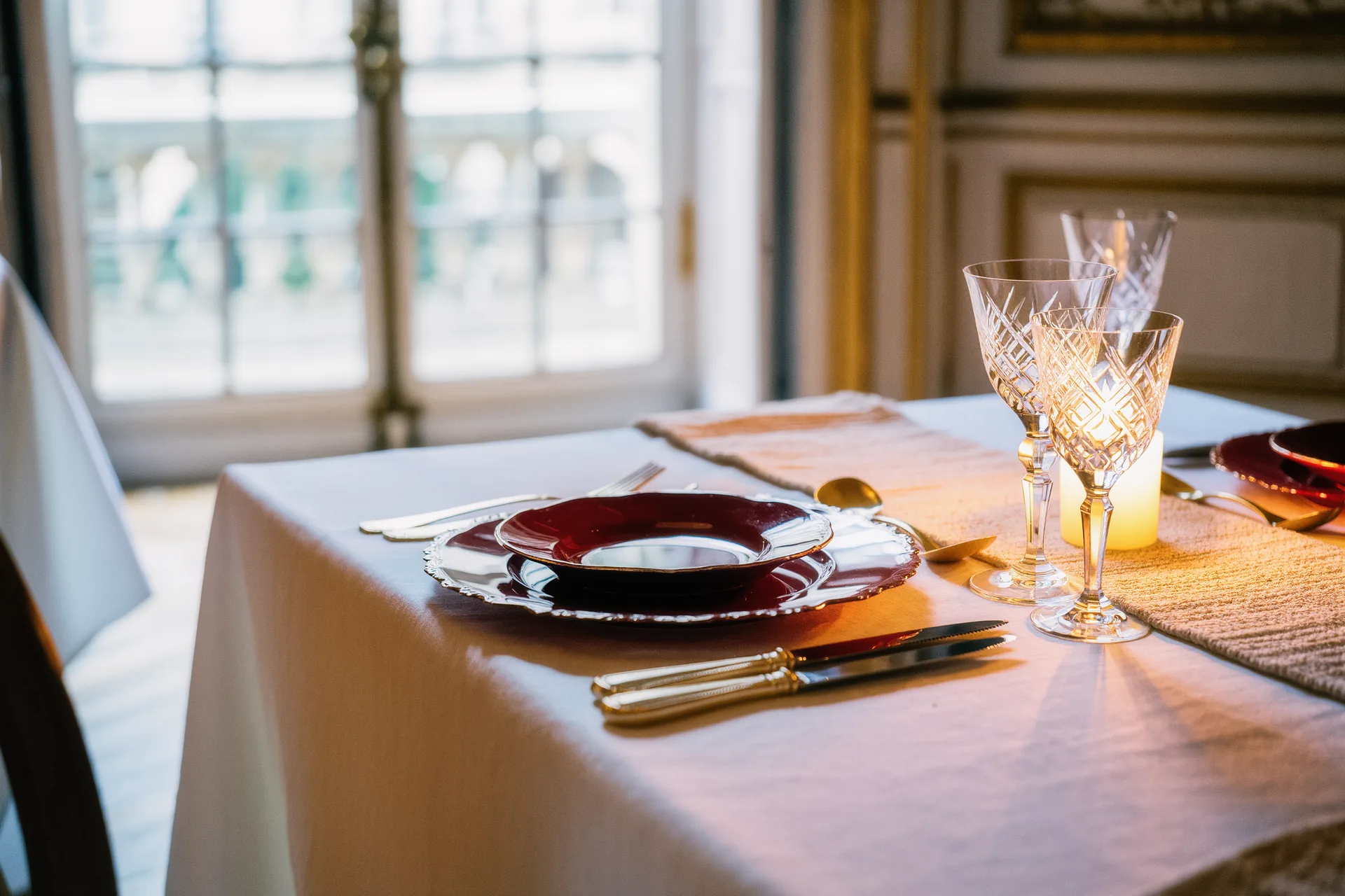 Nappe en lin blanc et chemin de table texturé dressés pour un déjeuner lumineux