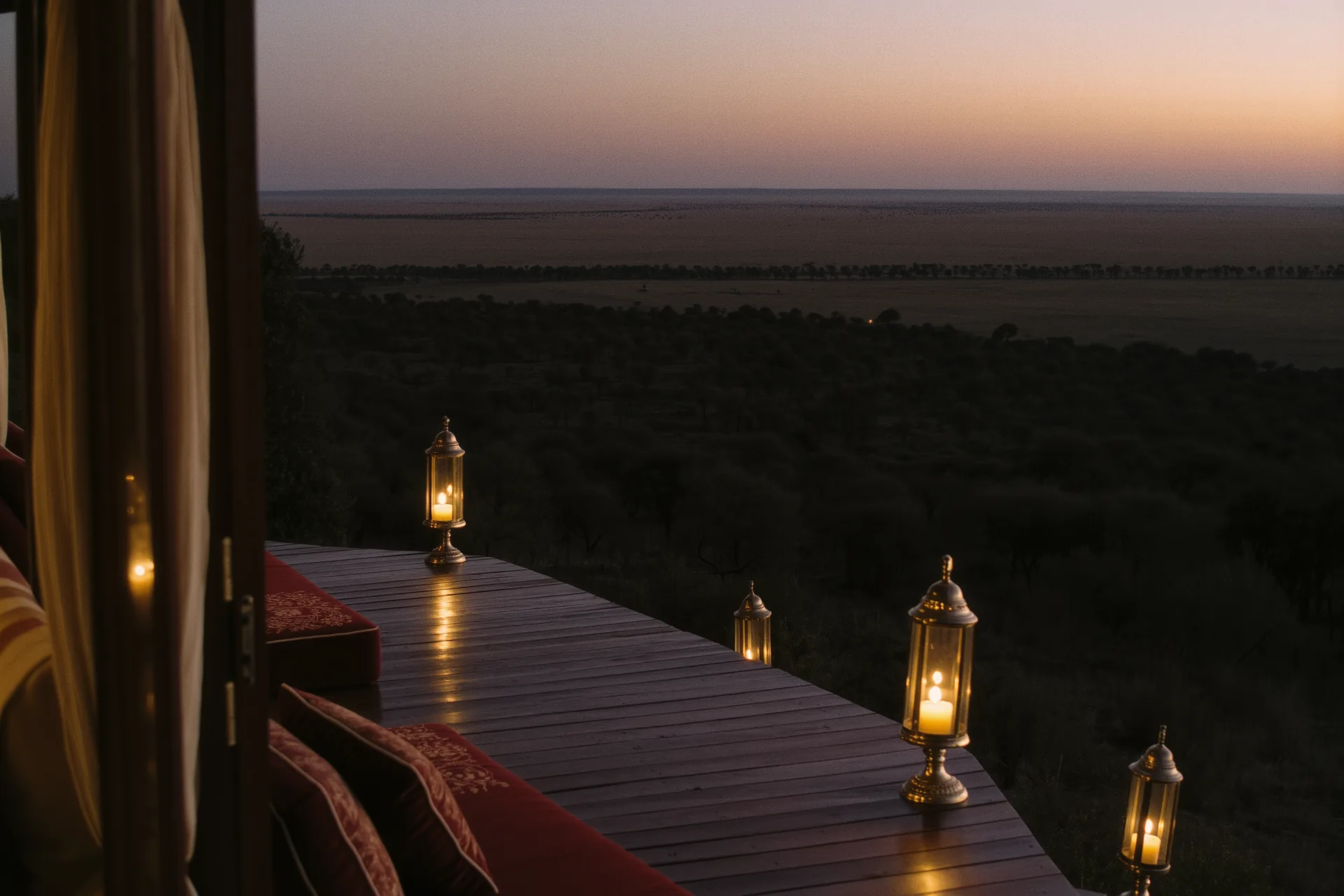 Terrasse en bois d'un lodge de safari surplombant la savane au crépuscule