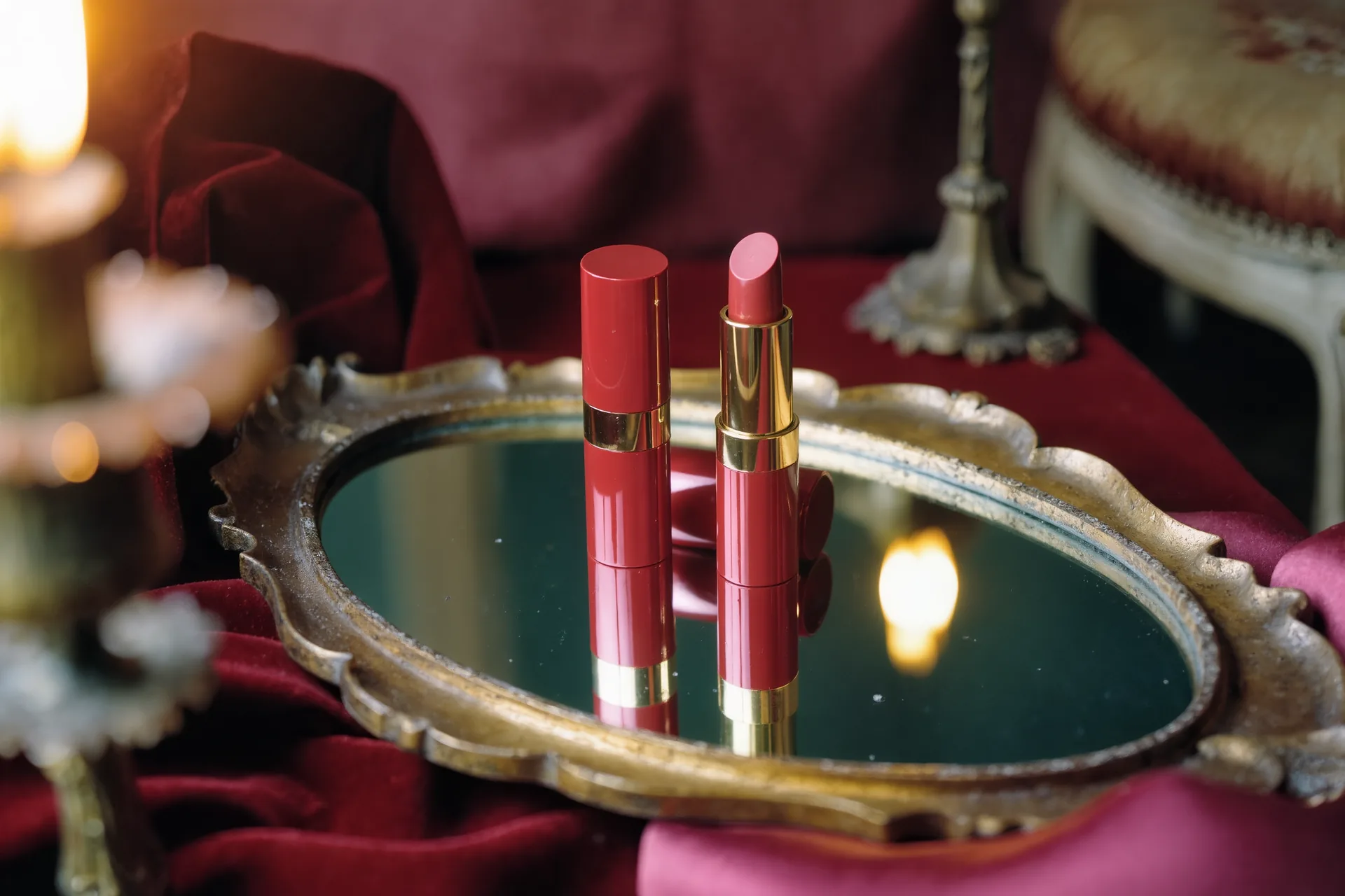 Tube de rouge à lèvres rouge classique posé sur un miroir de coiffeuse ancien