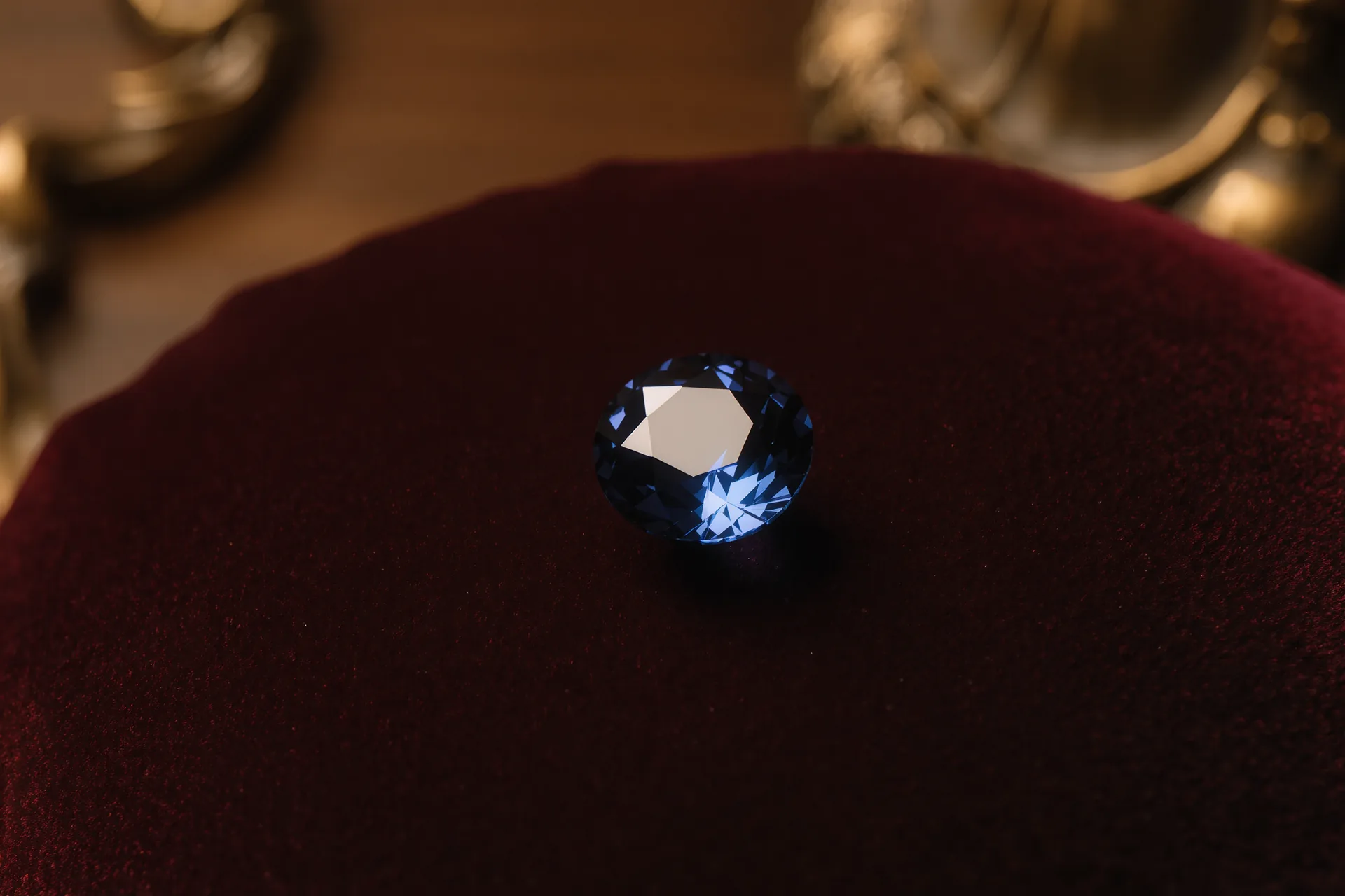 Gros plan sur un saphir taillé bleu profond posé sur un velours sombre