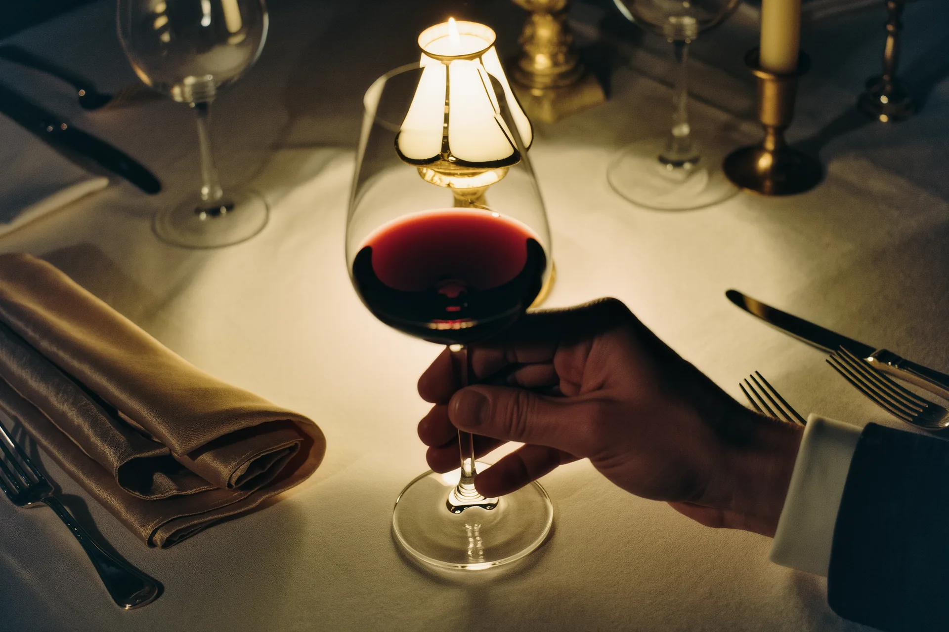 Sommelier versant du vin dans un verre en cristal sur une table dressée