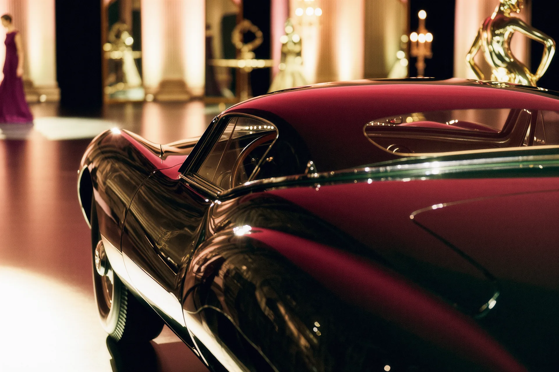 Carrosserie automobile sous lumière rasante révélant les reflets superposés d'un vernis profond